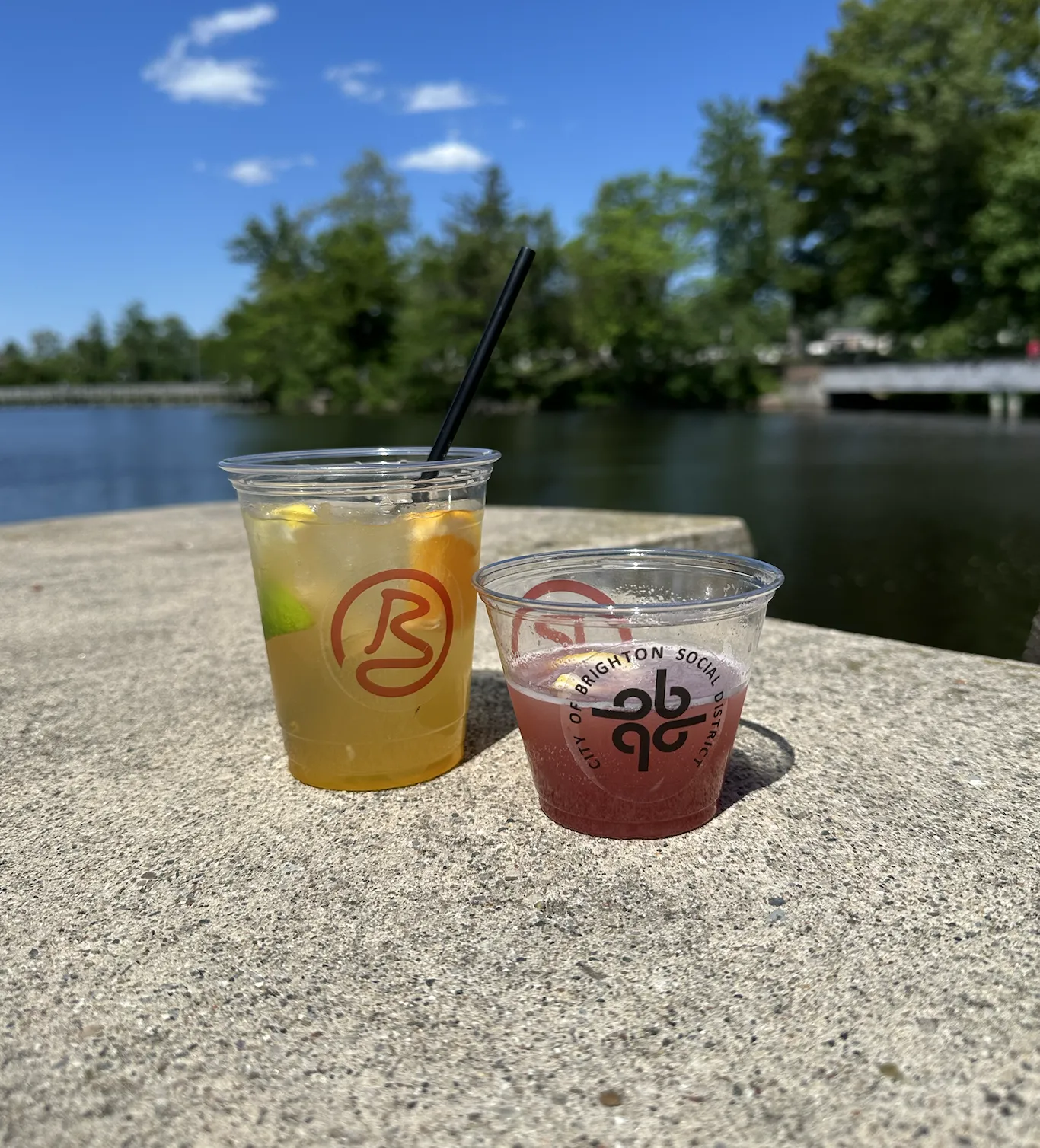 two cocktails overlooking the brighton mill pond on a sunny summer day